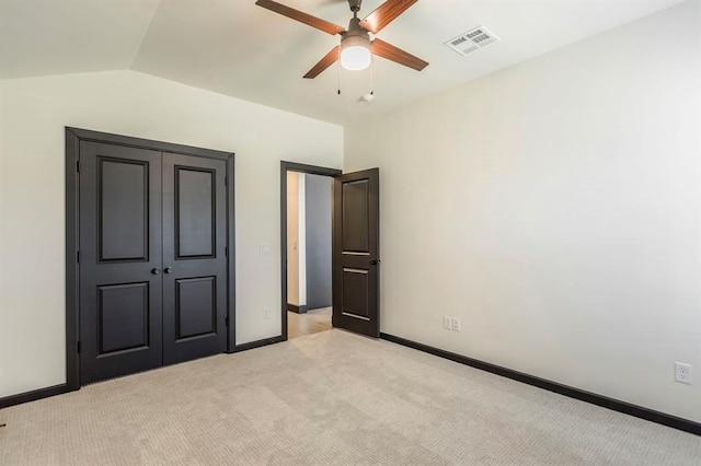 unfurnished bedroom featuring ceiling fan, light colored carpet, and vaulted ceiling