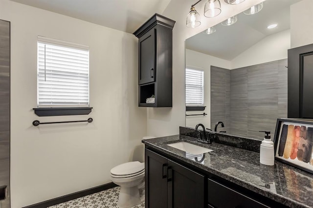 bathroom with toilet, vanity, vaulted ceiling, and plenty of natural light