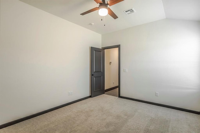 carpeted empty room with ceiling fan and vaulted ceiling