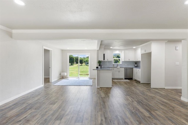 kitchen with white cabinetry, stainless steel dishwasher, backsplash, hardwood / wood-style floors, and a textured ceiling