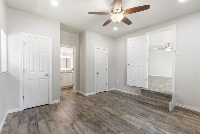 unfurnished bedroom with connected bathroom, ceiling fan, and dark wood-type flooring