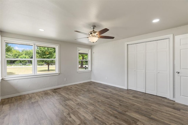 unfurnished bedroom with ceiling fan, a closet, and dark hardwood / wood-style floors