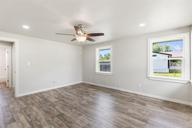 empty room featuring hardwood / wood-style flooring, ceiling fan, and a healthy amount of sunlight