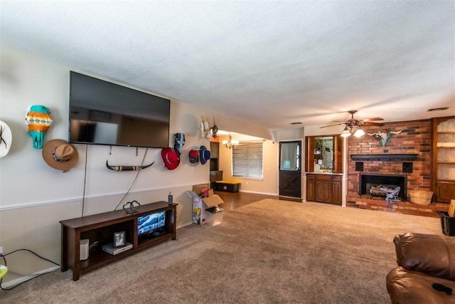 carpeted living room featuring a fireplace and ceiling fan with notable chandelier