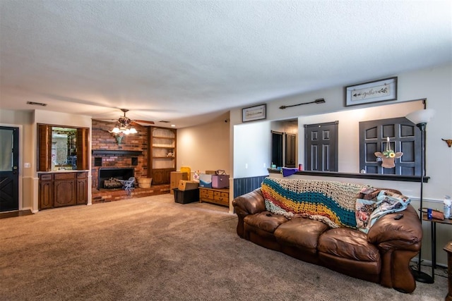 carpeted living room featuring ceiling fan, a textured ceiling, and a brick fireplace