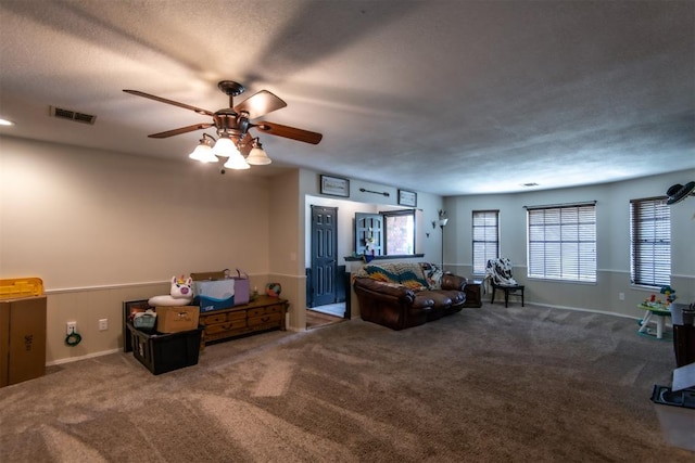 living room with carpet floors, ceiling fan, and a healthy amount of sunlight