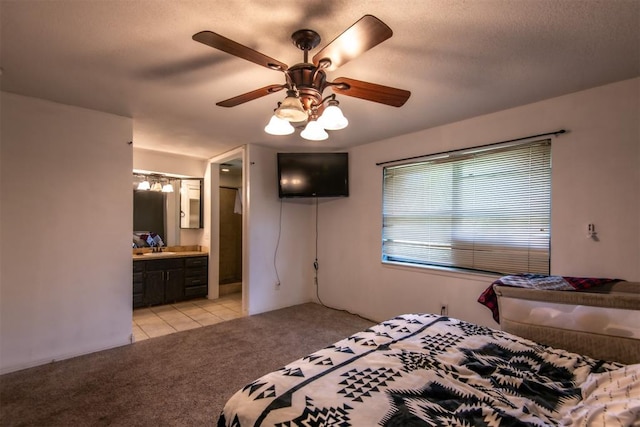 carpeted bedroom featuring ceiling fan, sink, a textured ceiling, and ensuite bath