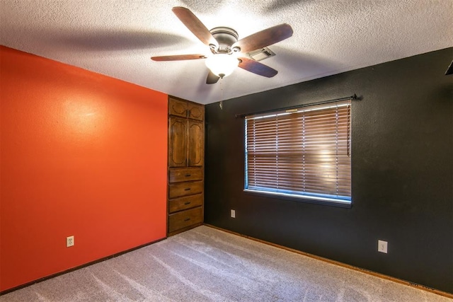 interior space featuring ceiling fan, light colored carpet, and a textured ceiling