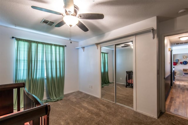 carpeted bedroom with a textured ceiling, a closet, and ceiling fan