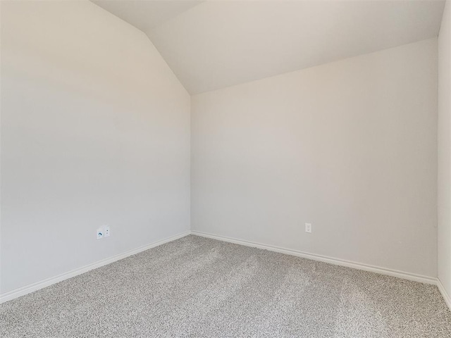 carpeted spare room featuring lofted ceiling