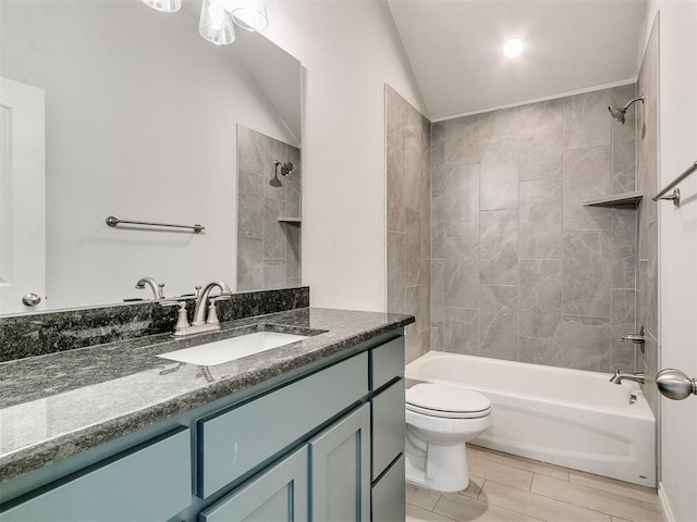 full bathroom with tiled shower / bath combo, toilet, vanity, and vaulted ceiling