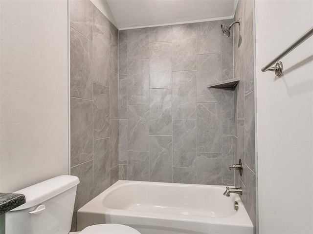 bathroom featuring tiled shower / bath combo and toilet