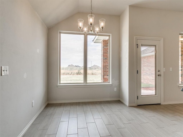 unfurnished dining area featuring vaulted ceiling, light hardwood / wood-style flooring, a wealth of natural light, and a chandelier