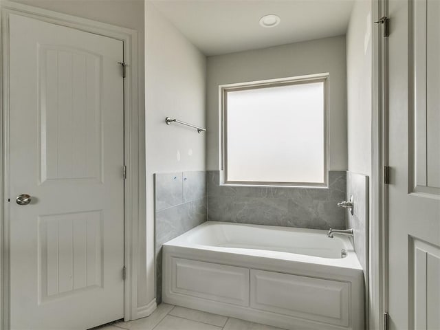 bathroom with a washtub and tile patterned flooring