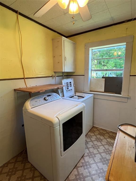 clothes washing area with washer and dryer, crown molding, ceiling fan, and cabinets