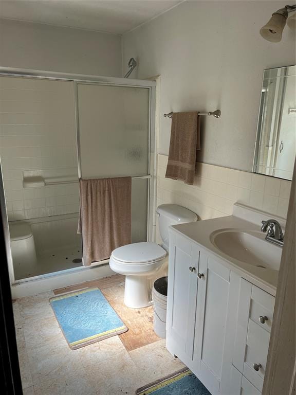 bathroom featuring toilet, vanity, and walk in shower