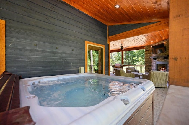 exterior space featuring vaulted ceiling, a jacuzzi, wooden ceiling, and wood walls