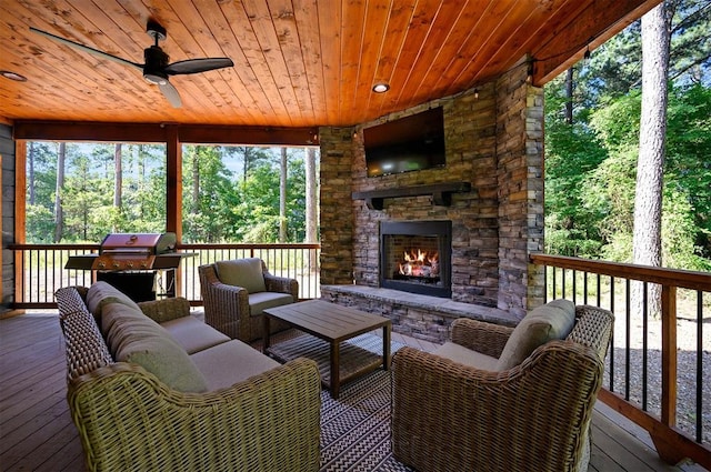 wooden deck with an outdoor living space with a fireplace, area for grilling, and ceiling fan