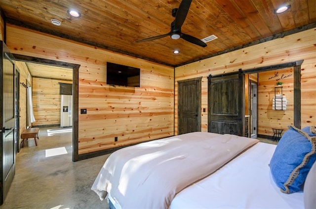 bedroom with wood walls, a barn door, wooden ceiling, and concrete floors