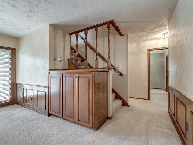 stairway featuring carpet flooring and a textured ceiling