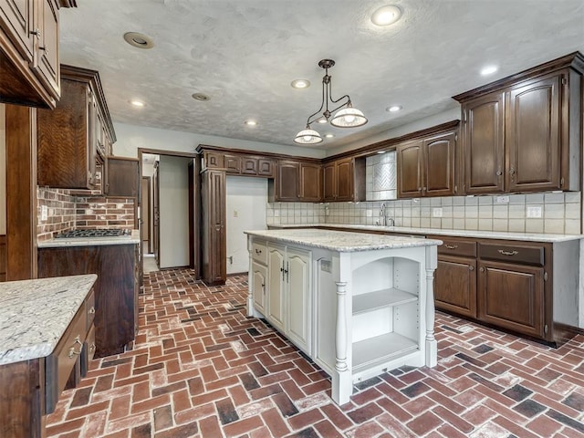 kitchen with open shelves, brick floor, dark brown cabinets, and tasteful backsplash
