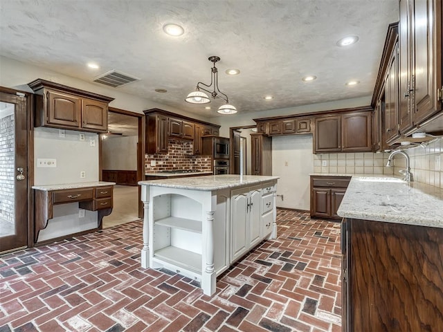 kitchen featuring decorative backsplash, open shelves, a sink, brick floor, and recessed lighting