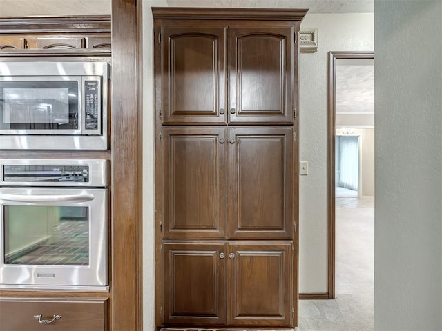kitchen with stainless steel appliances and a textured wall