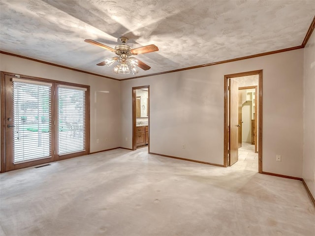 spare room featuring ceiling fan, visible vents, crown molding, baseboards, and light carpet