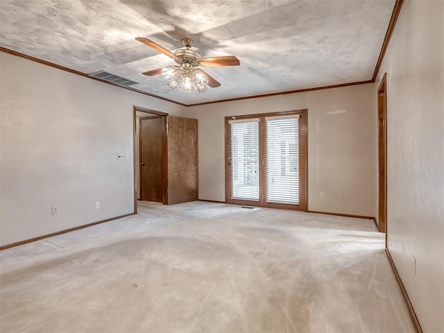 empty room featuring crown molding, a ceiling fan, baseboards, and visible vents