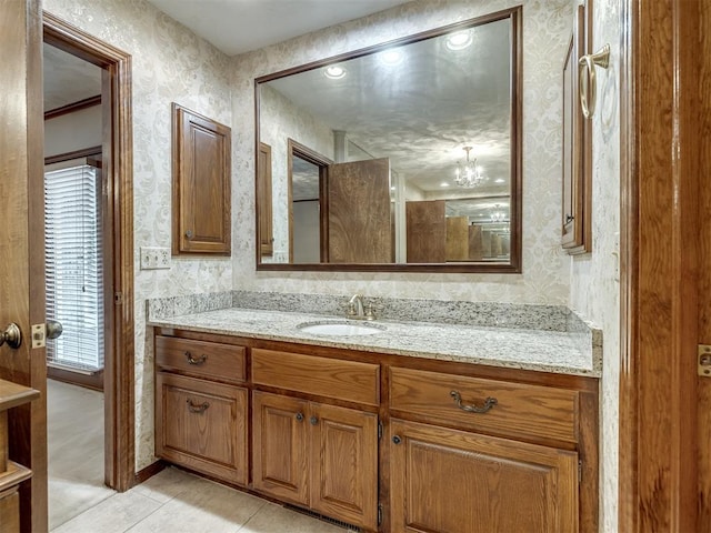 bathroom with wallpapered walls, tile patterned floors, and vanity