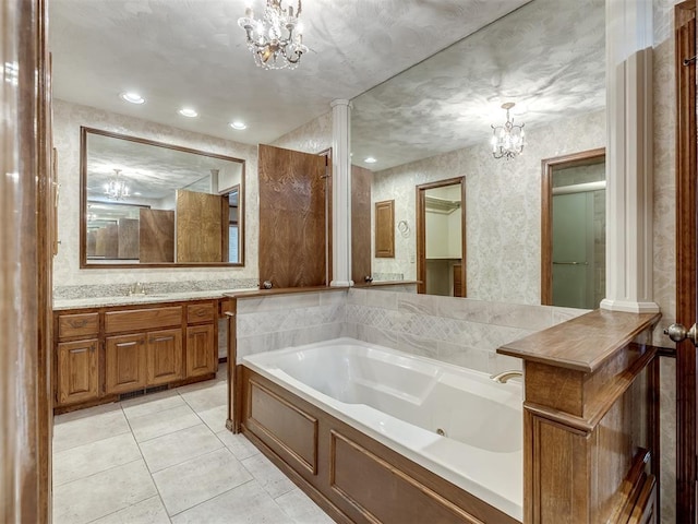 bathroom with tile patterned flooring, a tub with jets, vanity, a notable chandelier, and wallpapered walls