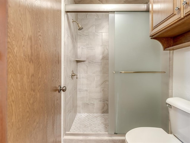 full bath featuring toilet and a shower stall