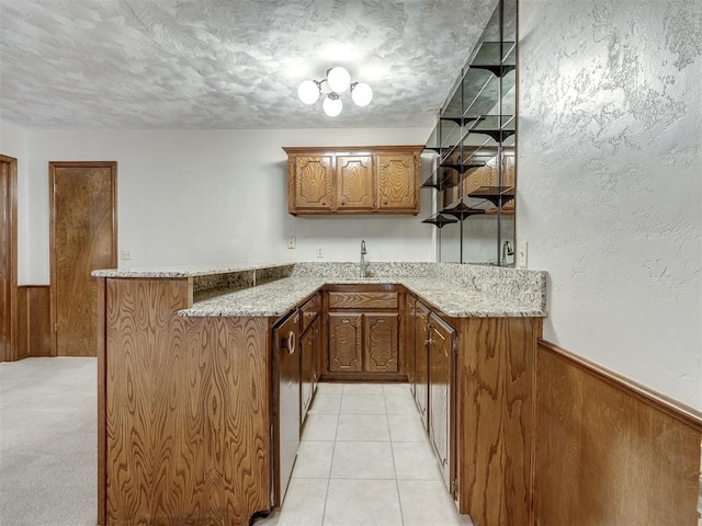 bar featuring a sink, wood walls, wet bar, and a wainscoted wall