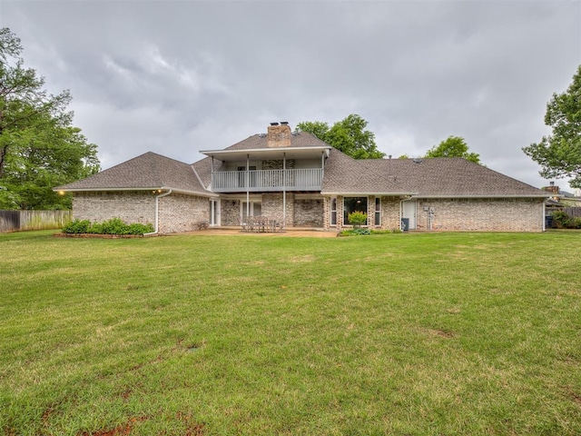 back of property with a lawn, fence, a chimney, and a patio area