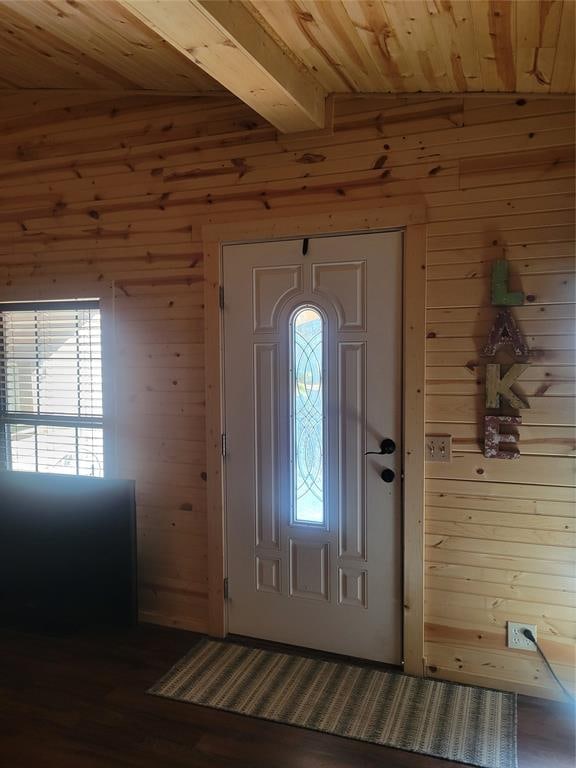 entryway with wood walls, lofted ceiling with beams, dark hardwood / wood-style floors, and wooden ceiling