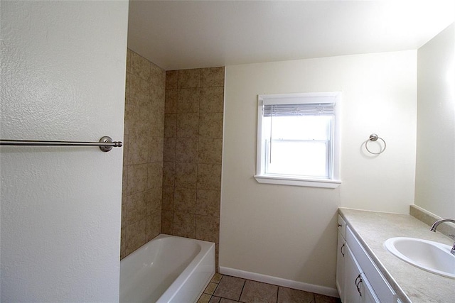 bathroom with tile patterned flooring, vanity, and tiled shower / bath