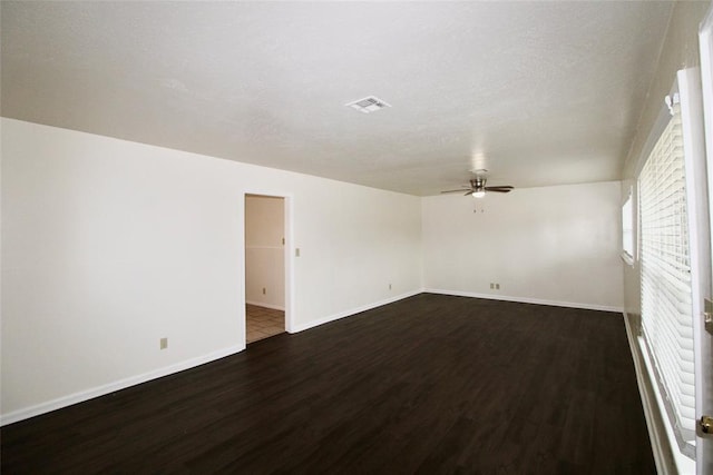 unfurnished room featuring dark hardwood / wood-style floors, ceiling fan, and a textured ceiling