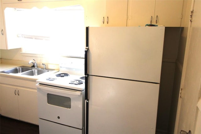 kitchen featuring sink, white cabinets, and white appliances