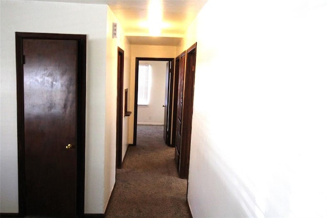 corridor featuring dark colored carpet