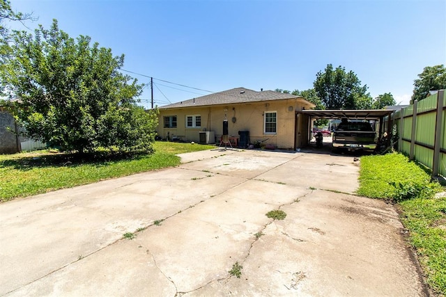 back of property featuring a carport and central AC unit