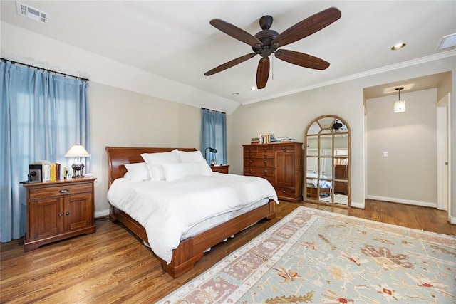 bedroom featuring ceiling fan, crown molding, and light wood-type flooring