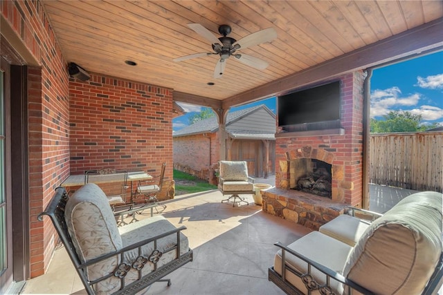 view of patio featuring an outdoor stone fireplace and ceiling fan