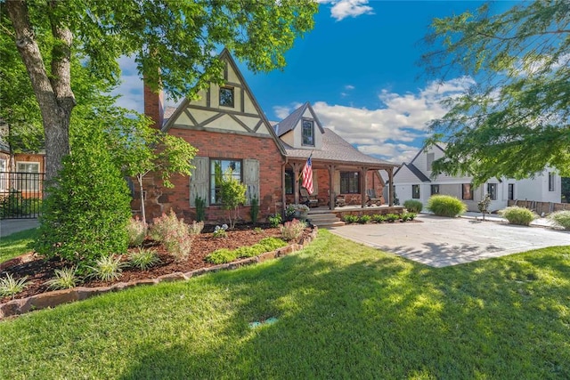 english style home featuring a front lawn