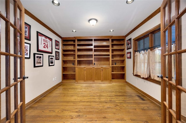 unfurnished office featuring ornamental molding, light hardwood / wood-style flooring, and french doors