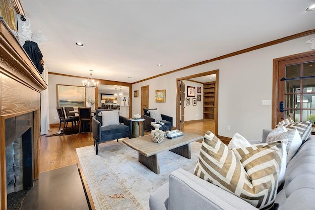 living room with a chandelier, light hardwood / wood-style floors, and crown molding