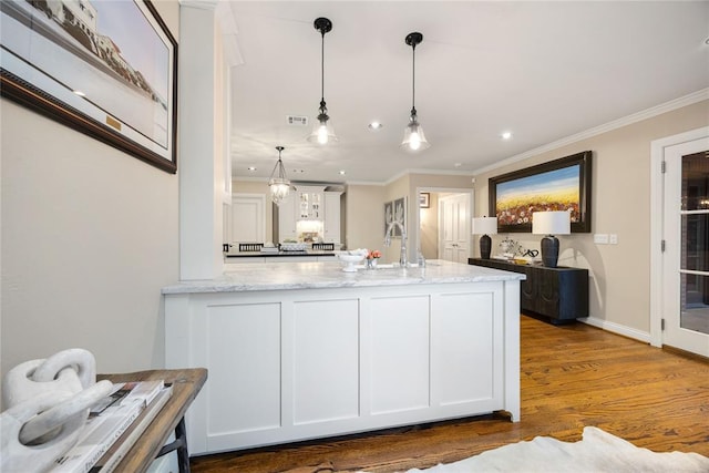 kitchen featuring white cabinetry, pendant lighting, light stone counters, and dark hardwood / wood-style floors