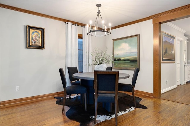 dining space featuring crown molding, wood-type flooring, and an inviting chandelier