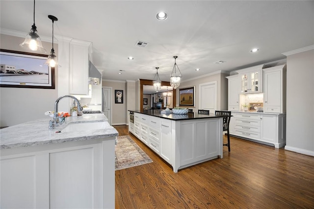 kitchen with white cabinets, decorative light fixtures, dark hardwood / wood-style floors, and sink