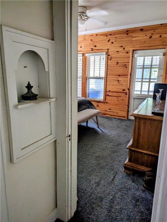 315 W Filmore St, Mangum, OK 73554 - carpeted bedroom with multiple windows and wooden walls