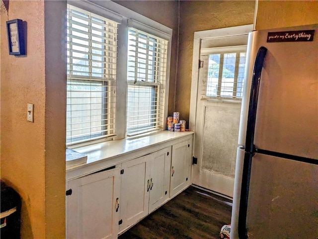 315 W Filmore St, Mangum, OK 73554 - kitchen featuring freestanding refrigerator, white cabinetry, light countertops, dark wood finished floors, and a textured wall